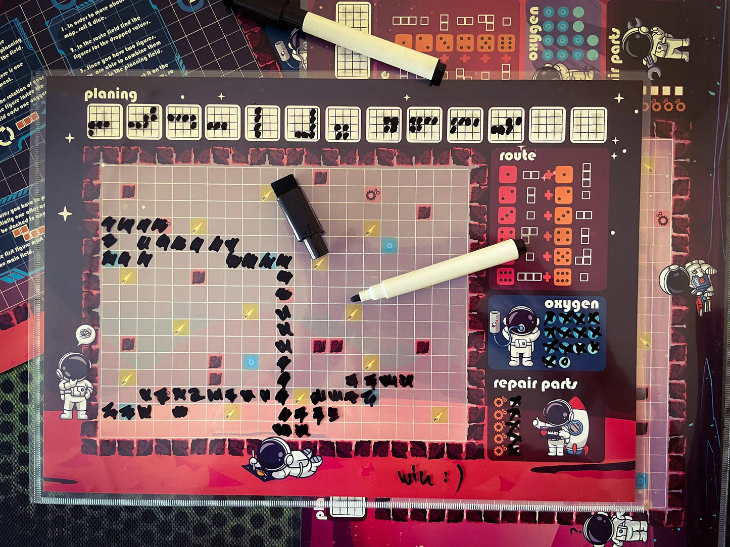 A photo of the "Micro Mars" Roll&Write game map with a marker pen, showing how players use the sheet and pen during gameplay.