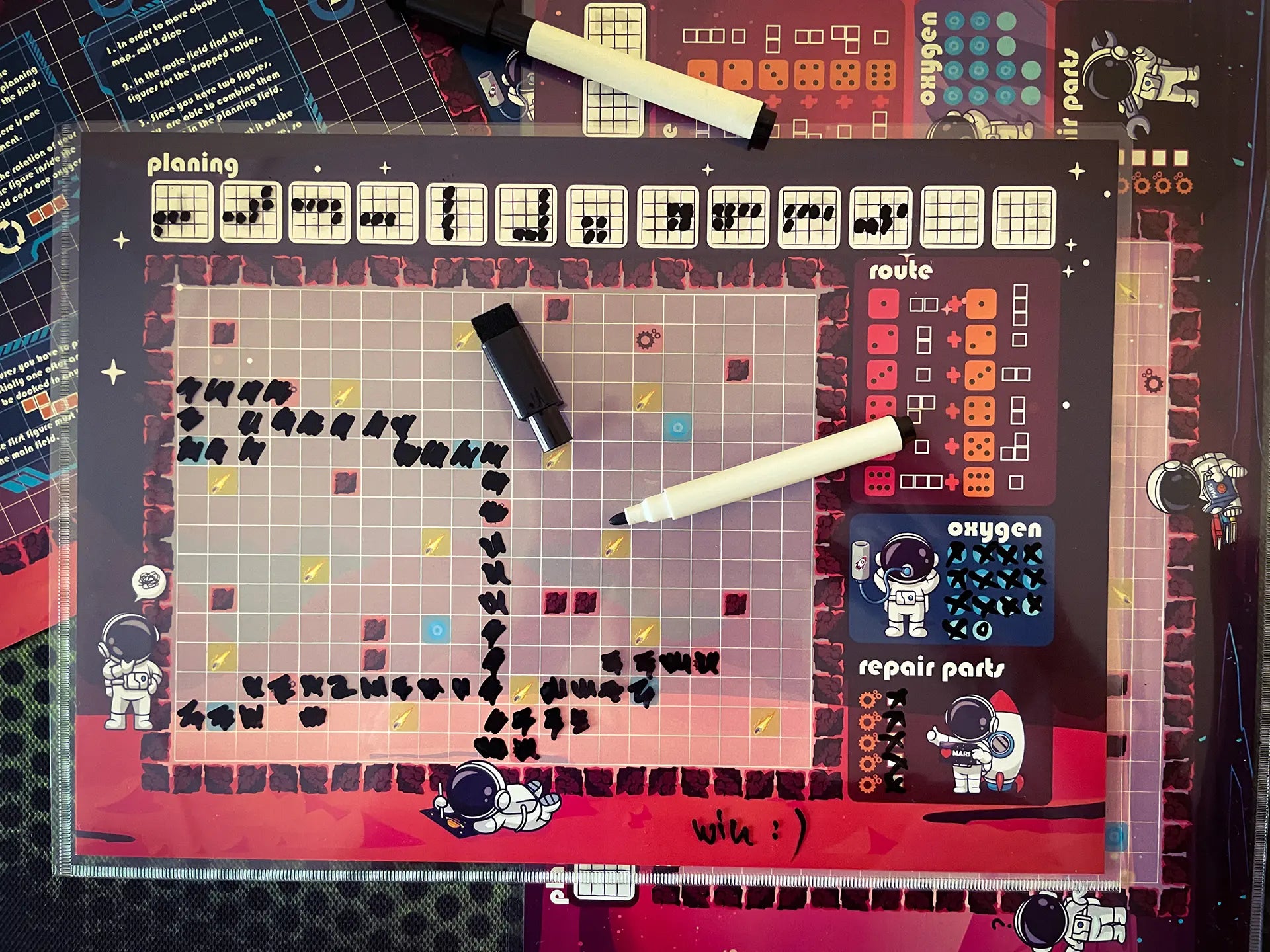 A photo of the "Micro Mars" Roll&Write game map with a marker pen, showing how players use the sheet and pen during gameplay.